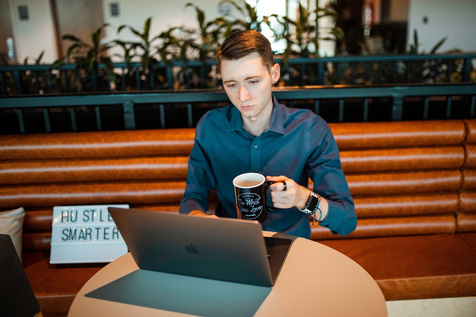 woman in blue blazer sitting on chair while using macbook