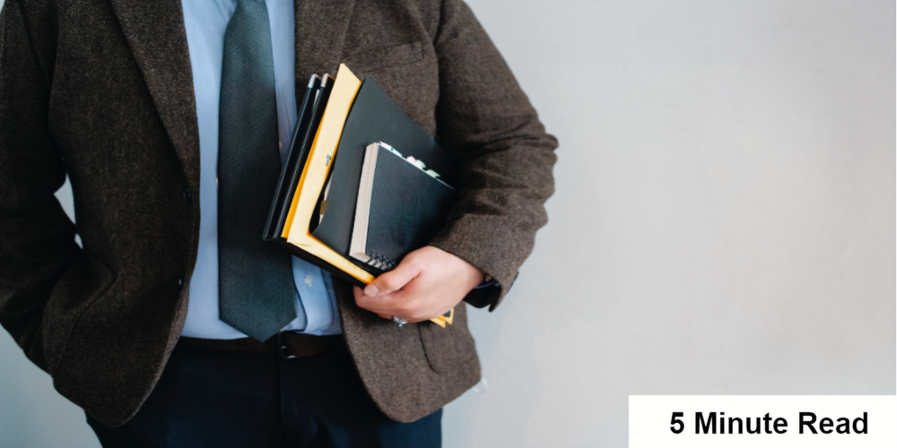 A man holding a bunch of files in his left hand